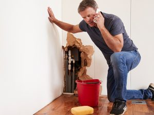 A man calling a licensed plumber to fix pipes.