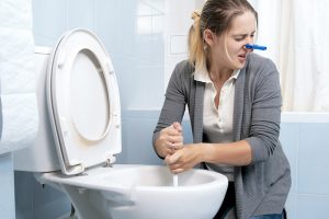 woman cleaning toilet smells sewer odor