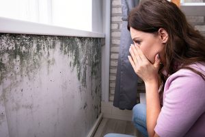 woman sees mold as a result of broken sewage pipes in her walls