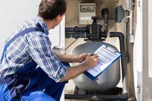 plumber checking water heater causing brown water from taps