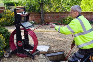 A master plumber using hydro-jetting to clear up a clog.